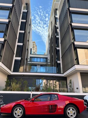 A modern building with a red sports car parked in front. - Appartement de Luxe 3BR vue sur la Mer (Beausoleil)