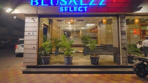 The exterior of a hotel named 'BLUSALZZ SELECT' with a modern entrance, potted plants, and a visible staircase leading inside. - BluSalzz Select City Centre near Golden Temple (Amritsar)