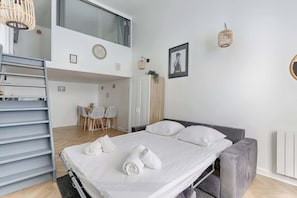 Una habitación de hotel moderna con una cama, un escritorio y una zona de comedor.