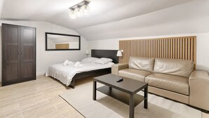 A modern bedroom with a bed, a sofa, a desk, and a wardrobe. - Batignolles Epinette Lovely Apartment 6P (Paris)