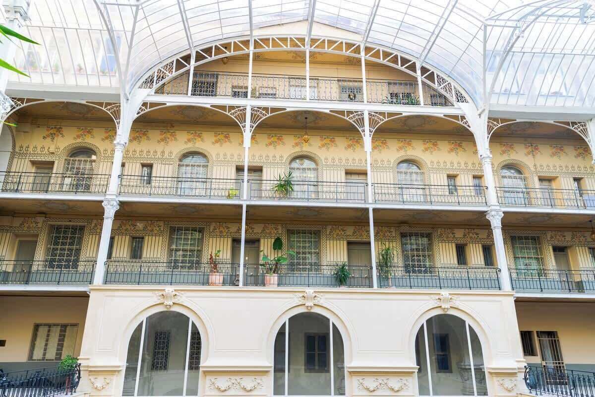 A multi-story building with a glass roof and ornate balconies.