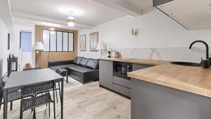 Et moderne køkken med en træbordplade, en indbygget ovn og en sort vandhane.