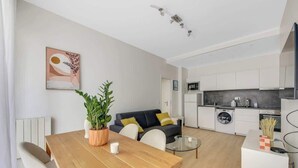 Eine moderne Wohnung mit Essbereich, Wohnzimmer und Küche.