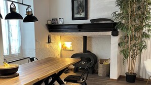 A cozy dining area with a wooden table, black chairs, a bench with a cowhide cover, and a potted bamboo plant.