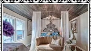 Una habitación con cama, sofá, candelabro y un cuadro.