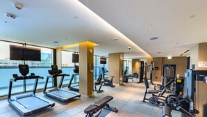 Una palestra moderna con tapis roulant, cyclette e macchinari per l'allenamento con i pesi.