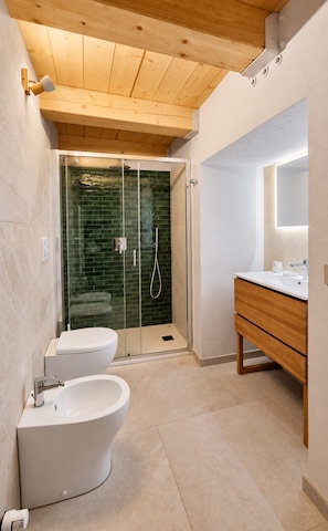 Une salle de bain moderne avec une douche à parois de verre, une baignoire sur pieds et un meuble-lavabo avec un miroir.