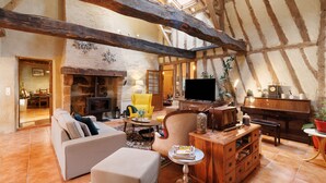 A spacious living area with a fireplace, a television, and a piano.