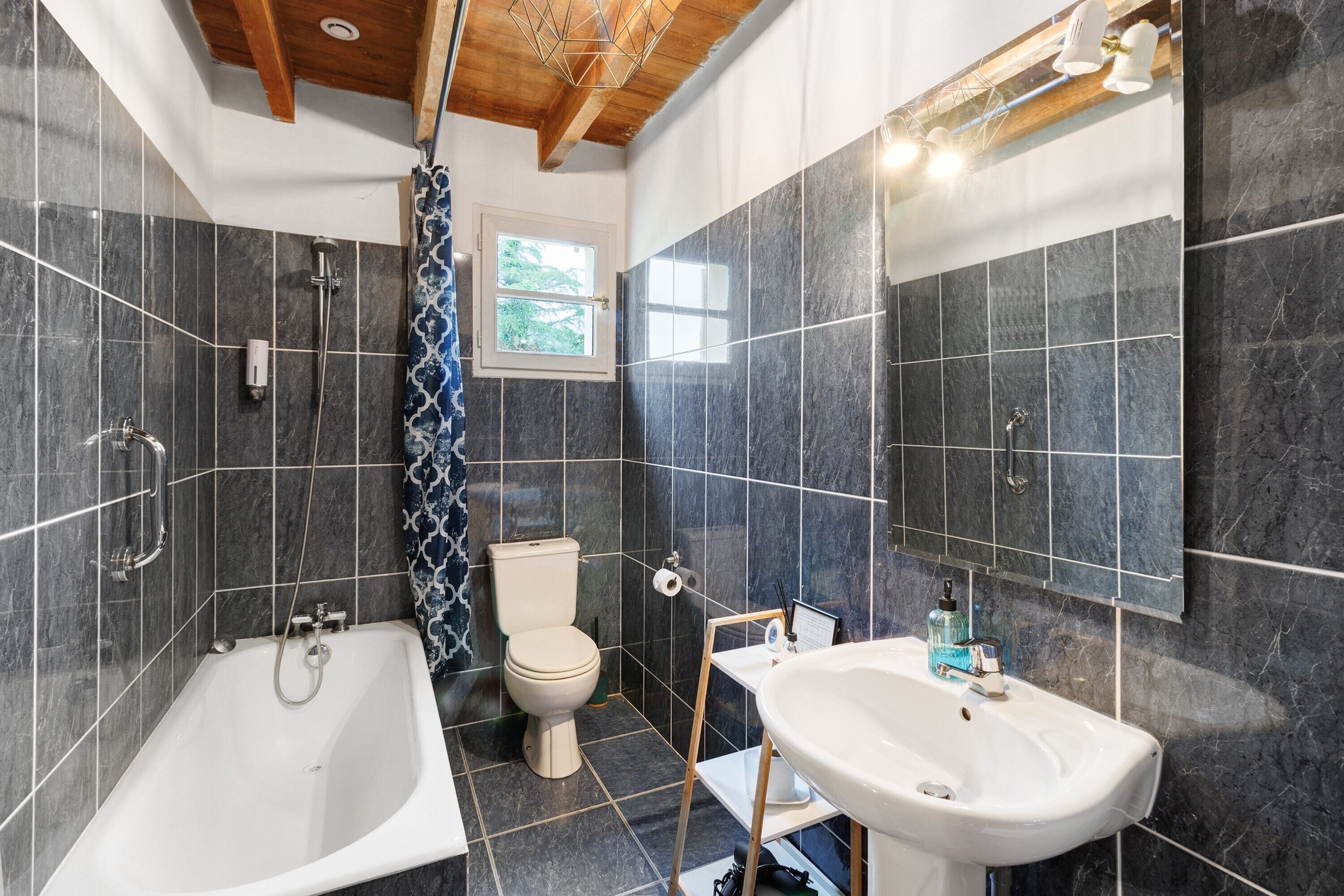 Een badkamer met een bad, toilet en wastafel, alles met moderne sanitair.