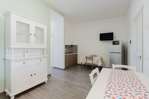 A kitchen with white cabinets, a microwave, and a refrigerator.
