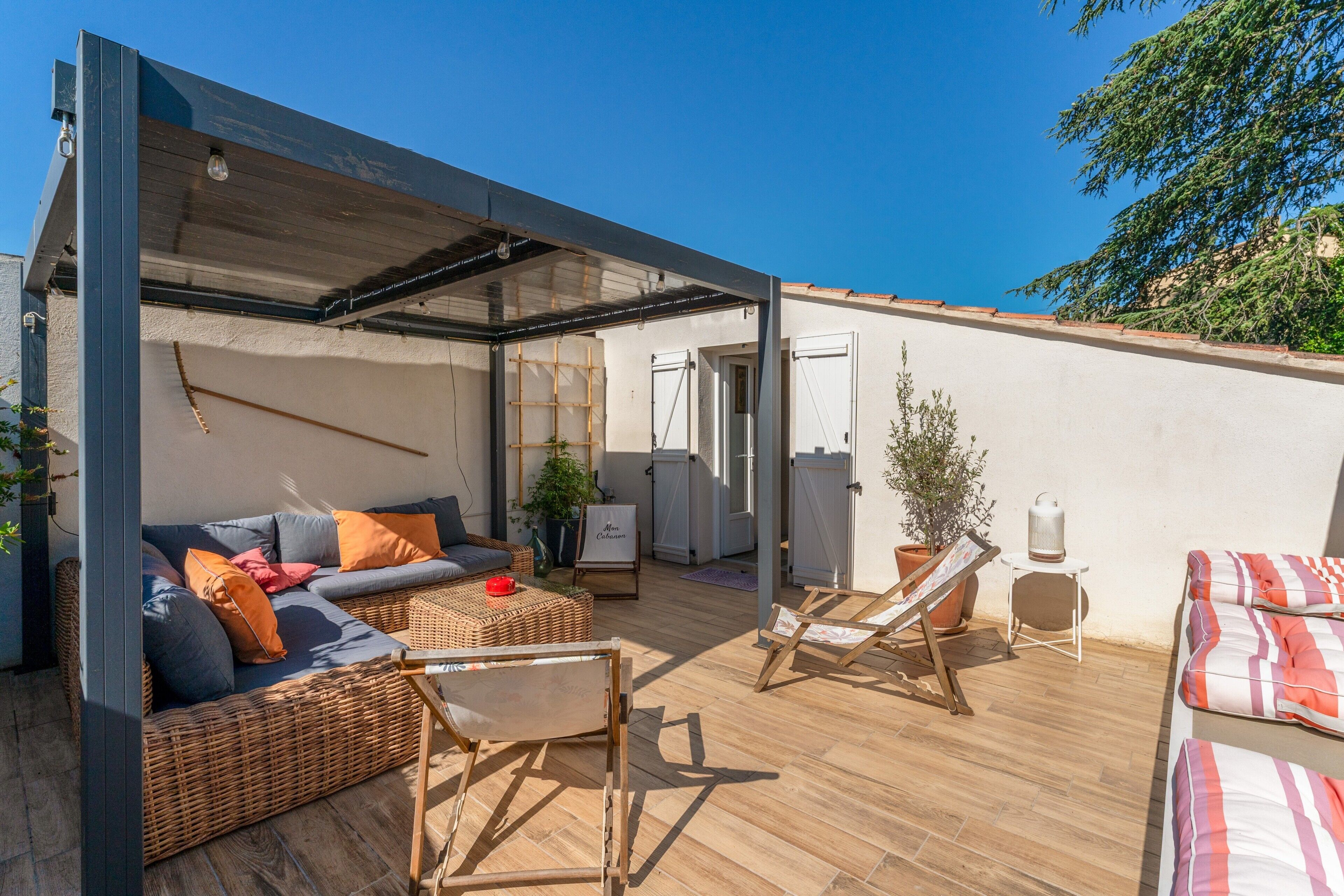 Un espace extérieur aménagé, abrité et doté d’un canapé, de chaises et d’une table.