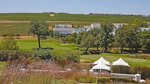Un parcours de golf avec des bâtiments blancs, des tentes et un ciel dégagé.