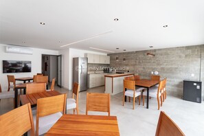 Eine moderne Küche mit Steinrückwand, Holztisch und Stühlen.