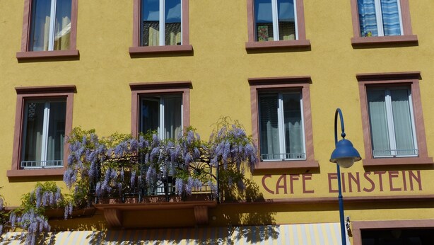 A yellow building with multiple windows and a sign that reads 'CAFE EINSTEIN.' - Apartment 'Topas' with Wi-Fi (Freiburg im Breisgau)