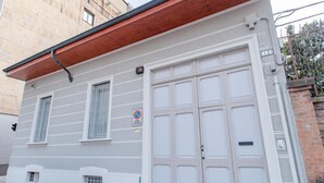 Un edificio con fachada blanca, una puerta de garaje grande y un letrero de no estacionamiento.
