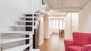 A modern interior with a staircase, a dining area, and a red sofa. - [Centro]: Dream Loft by HappyHosTorino (Torino)