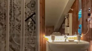 A bathroom with a shower, sink, and mirror.