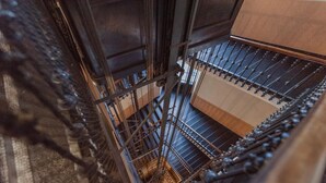 A spiral staircase with metal railings and wooden steps. - Enjoy Torino City Center (Torino)