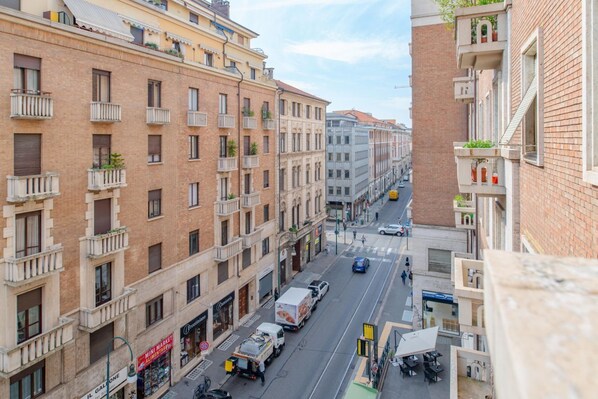 A street view of a city with multi-story buildings, parked vehicles, and a visible storefront. - San Tommaso, Luxury, 4 rooms by HappyHosTorino (Torino)
