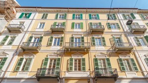 A multi-story building with balconies, a shop on the ground floor, and a sign for 'Belle Art'. - Casa Mimmo by Happyhostorino (Turin)