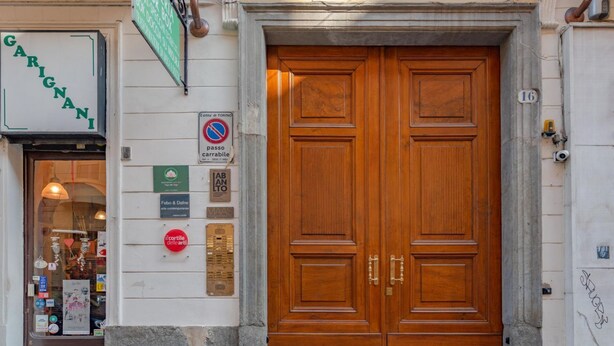 A double wooden door with a plaque and a no parking sign. - Casa Mimmo by Happyhostorino (Turin)