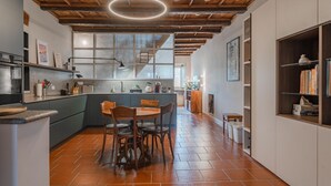 A modern kitchen with a central island, wooden chairs, and a dining table. - Casa Mimmo by Happyhostorino (Turin)