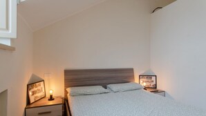 Une chambre à coucher avec un lit, des tables de chevet et une petite table de nuit avec une lampe.