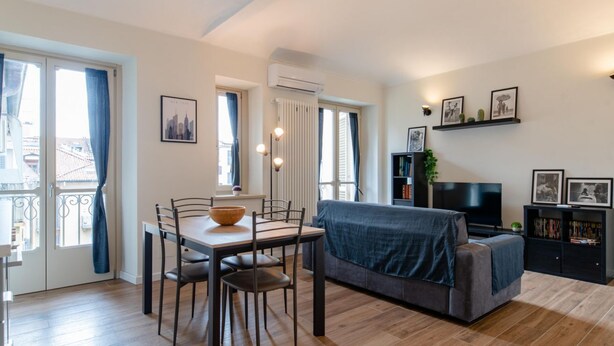 Un salon moderne avec une table à manger, un canapé et un téléviseur.