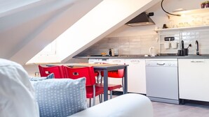 A modern kitchen with white cabinets, a dishwasher, and red chairs. - Balon Turin View (Airco, Centrale)  (Torino)