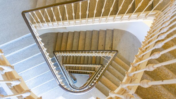 A spiral staircase with a metal railing and a geometric pattern on the steps. - Balon Turin View (Airco, Centrale)  (Torino)