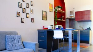 Una cocina moderna con una isla central, taburetes de bar y una pared de acento roja.
