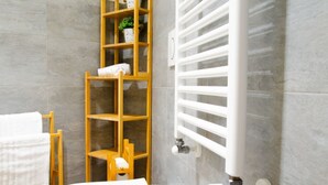 A modern bathroom with a toilet, a wooden shelf unit, and a white towel rack. - [Zona Borgo Dora] La Terrazza by HappyHosTorino (Torino)