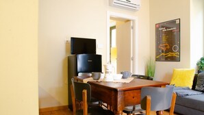 A dining area with a wooden table, four chairs, a black refrigerator, and a white air conditioner. - [Zona Borgo Dora] La Terrazza by HappyHosTorino (Torino)