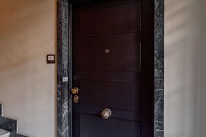 A dark wooden door with a keypad lock and a keyhole. - [monolocale, Wifi] Casa Amely (Torino)