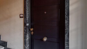Een donker houten deur met een cijferslot en een sleutelgat.