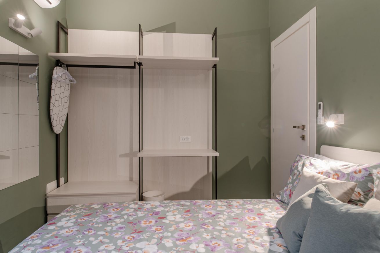Een slaapkamer met een bed, een kledingkast en een badkamer.