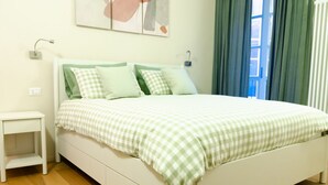 Ein Schlafzimmer mit einem Bett, einem Nachttisch und einem Fenster mit Vorhängen.