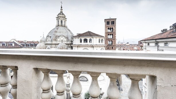 A view of a historic building with a dome and bell tower from a balcony.