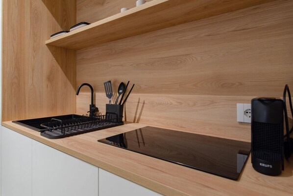A modern kitchen with a wooden countertop, a built-in stove, and a black electric kettle. - [Centro, AC] Casa Ivette (Torino)