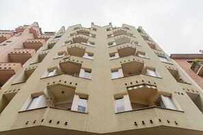 Een meerhoog gebouw met een symmetrische gevel, voorzien van balkons en ramen.