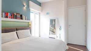 Une chambre à coucher avec un lit, une bibliothèque, une porte et un miroir.