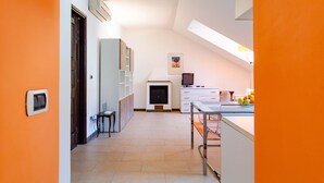 A modern kitchen with white cabinets, a dining table, and a small island. - Ca' Vittoria by HappyHosTorino (Torino)