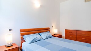 A neatly arranged bedroom with a bed, bedside tables, and a dresser. - Ca' Vittoria by HappyHosTorino (Torino)