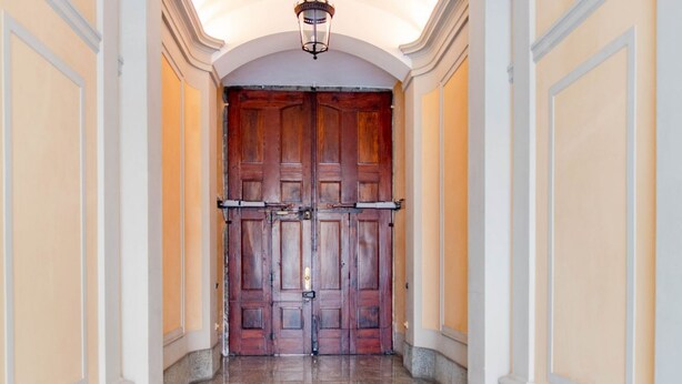 A hallway with a double wooden door, marble flooring, and a light fixture above. - [Centro, elegante]: The Queen by HappyHosTorino* (Torino)
