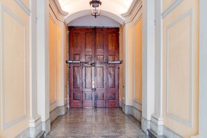A hallway with a double wooden door, marble flooring, and a light fixture above. - [Centro, elegante]: The Queen by HappyHosTorino* (Torino)