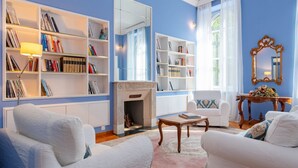 A living room with white sofas, a fireplace, and bookshelves filled with books. - [Centro, elegante]: The Queen by HappyHosTorino* (Torino)