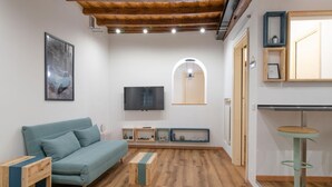 Ein modernes Wohnzimmer mit einer Couch, einem Couchtisch, einem Fernseher und einer Holzzahl.