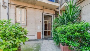 Un estrecho sendero de piedra que lleva a la entrada de un edificio, con una puerta y una ventana.