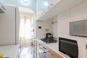 Una cocina moderna con estufa a gas, horno y microondas integrado.