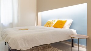 A bedroom with a bed, a small round table, and a fluffy rug. - La Terrazza sui Tetti (Torino)